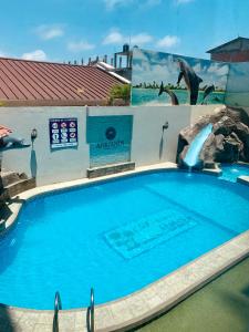 einen Pool in einem Resort mit einer Delphin-Wasserrutsche in der Unterkunft Hotel Adriand's in Machala