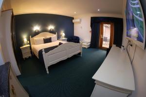 um quarto com uma cama branca num quarto em Sleepy Hill Motor Inn em Raymond Terrace