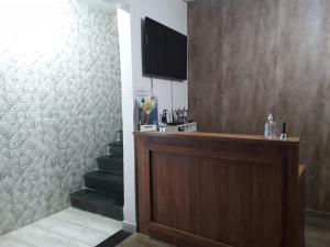 a room with a podium and stairs with a television at Pousada Mãe Padroeira in Aparecida