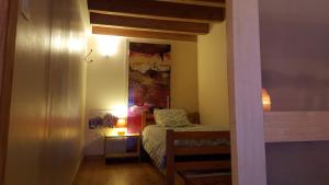 Habitación pequeña con cama y espejo. en Le Chalet du Parc, en Annonay