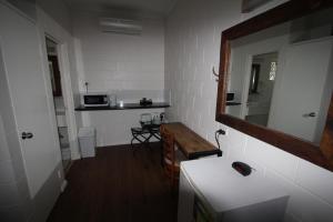 a small bathroom with a sink and a mirror at Colonial Rose Motel in Townsville
