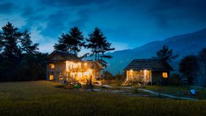 Deux maisons dans un champ la nuit dans l'établissement Lapantan Paradise, à Lao San Chay