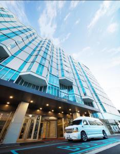 un coche blanco estacionado frente a un edificio en Hotel Sirius en Jeju