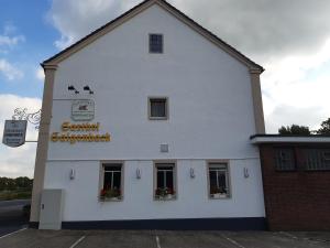 a white building with two windows and a sign on it at Steakhaus Galgenbach in Werne an der Lippe