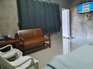 南邦的住宿－Baanrimdoi Resort Lampang，客房设有床、长凳和电视。