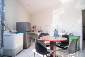 a kitchen with a table and chairs and a refrigerator at KoolKost Syariah near Stasiun Rawa Buntu (Minimum Stay 6 Nights) in Tangerang