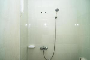 a bathroom with a shower with a toilet and a sink at KoolKost Syariah near Stasiun Rawa Buntu (Minimum Stay 6 Nights) in Tangerang +24 photos