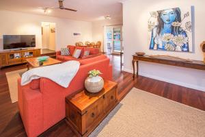 a living room with a red couch and a tv at Swell Shack in Dunsborough