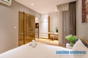 a bedroom with a white bed and a dining room at The Art - Sunshine Apartment in Ho Chi Minh City