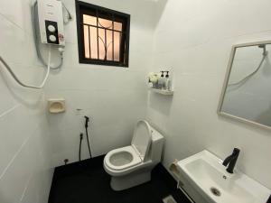 a white bathroom with a toilet and a sink at 118-Nineteen Hideout in Shah Alam