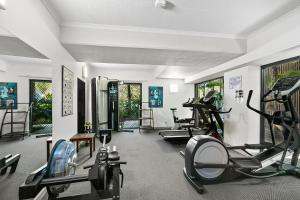 a gym with several treadmills and elliptical machines at Blue Lagoon Resort in Trinity Beach
