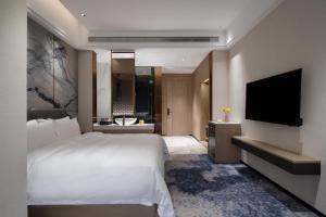 TV a/nebo společenská místnost v ubytování Paco Hotel Jinfeng Metro Guangzhou-Free Shuttle Bus For Canton Fair-Self-service laundry