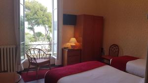 a hotel room with two beds and a window at Hôtel de Charme Brise Marine in Saint-Jean-Cap-Ferrat