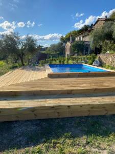 una terraza de madera con piscina en un patio en casa il colle con piscina privata, en Strada