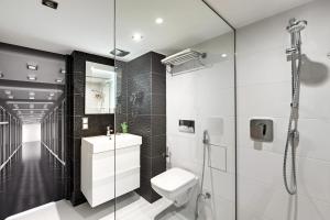 a white bathroom with a shower and a toilet at Panorama- the View of Gdańsk by Elite Apartments in Gdańsk