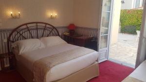 a bedroom with a bed and a door to a patio at Hôtel de Charme Brise Marine in Saint-Jean-Cap-Ferrat
