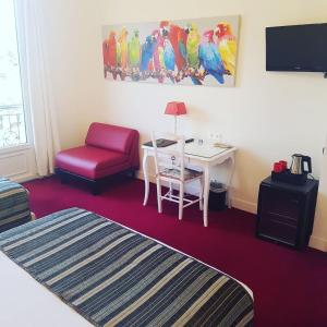 Cette chambre comprend un lit, une table et une chaise. dans l'établissement Hôtel de Charme Brise Marine, à Saint-Jean-Cap-Ferrat