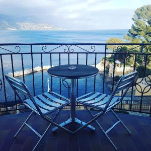 a table and two chairs on a balcony with the ocean at Hôtel de Charme Brise Marine in Saint-Jean-Cap-Ferrat