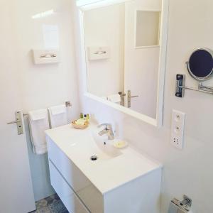 a white bathroom with a sink and a mirror at Hôtel de Charme Brise Marine in Saint-Jean-Cap-Ferrat