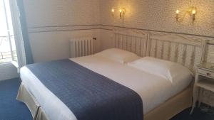 a bedroom with a large bed with white sheets and pillows at Hôtel de Charme Brise Marine in Saint-Jean-Cap-Ferrat