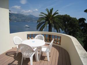 a table and chairs on a balcony with a view of the water at Hôtel de Charme Brise Marine in Saint-Jean-Cap-Ferrat