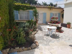 a patio with a table and chairs in front of a house at Hôtel de Charme Brise Marine in Saint-Jean-Cap-Ferrat