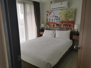 a bedroom with a white bed with a window at APARTMENTS MBC in Mai Khao Beach