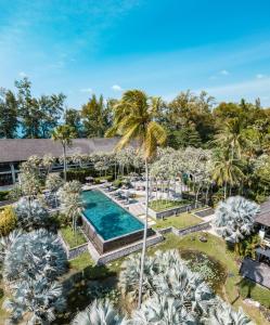 ein Luftblick auf ein Resort mit einem Pool und Palmen in der Unterkunft The Slate, Phuket in Nai Yang Beach
