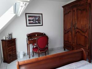 een slaapkamer met een bureau, een stoel en een bed bij L'atelier des Fées de l'Aff in Paimpont