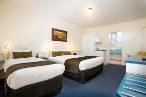 a hotel room with two beds and a television at Applegum Inn in Toowoomba