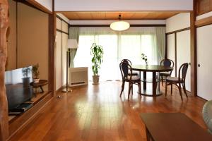sala de estar con mesa, sillas y TV en 山葵-WASABI en Kamakura