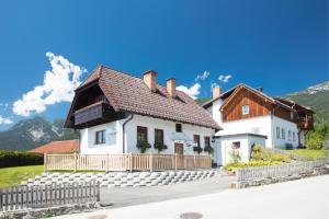 a white house with a brown roof at Chalet am See in Aich
