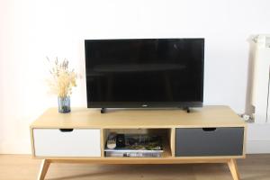 a flat screen tv sitting on a wooden tv stand at La Casa Toledana Estudio - Patio y Artesonado in Toledo