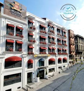ein großes weißes Gebäude mit roten Balkonen auf einer Straße in der Unterkunft Dosso Dossi Hotels Old City in Istanbul