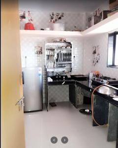 eine Küche mit einem Kühlschrank und einer Theke darin in der Unterkunft Savitri bungalow 3BHK in Panchgani