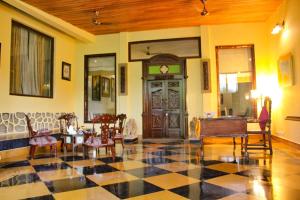una hall con pavimento a scacchi e porta in legno di Tree of Life Resort Dehradun Foothills a Dehradun
