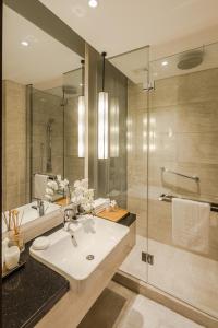 een badkamer met een wastafel en een douche bij Huangshan Demaotang Hotel in Huangshan