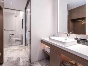 a bathroom with a sink and a mirror at Hampton by Hilton Qinhuangdao Jinmeng Bay in Qinhuangdao