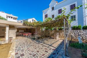 a courtyard in a house with a stone wall at Studio Apartments Apolonia in Novalja