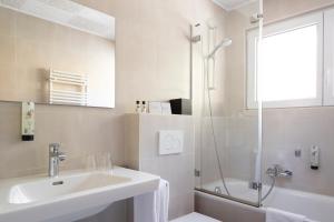 bagno bianco con lavandino e doccia di Hotel la Rotonde a Verbier