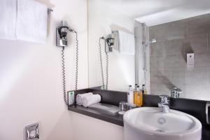 a bathroom with a sink and a mirror at Wyndham Stuttgart Airport Messe in Stuttgart