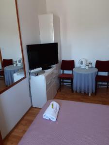 a living room with a tv and a table at Room-Delux- with a modern bathroom- - Primosten -Lokvice 6 in Primošten