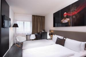 Habitación de hotel con cama y escritorio en Wyndham Stuttgart Airport Messe en Stuttgart