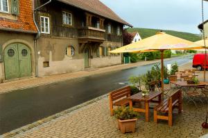 eine Terrasse mit einem Tisch und einem Sonnenschirm auf einer Straße in der Unterkunft Gasthof Krone in Schönau an der Brend