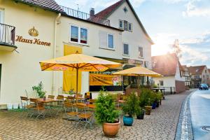 ein Restaurant mit Tischen und Sonnenschirmen auf einer Straße in der Unterkunft Gasthof Krone in Schönau an der Brend