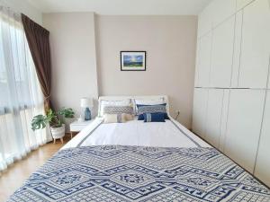 Un dormitorio con una cama con una colcha azul y blanca. en Stay Nimmanhemin Center with Rooftop Pool 309NM, en Chiang Mai 12 fotos más