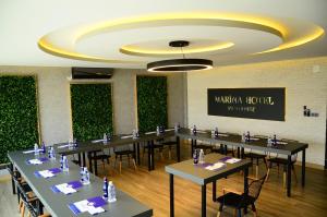 a conference room with tables and chairs and a wall of plants at Burhaniye Marina Boutique Hotel in Burhaniye