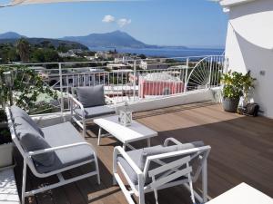 einen Balkon mit Stühlen, einem Tisch und Meerblick in der Unterkunft Le Volte Procida Home in Procida