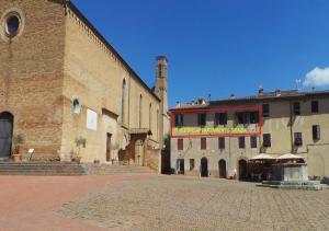 un gran edificio de ladrillo junto a un gran edificio en caratteristico appartamento Grazia centro storico, en San Gimignano