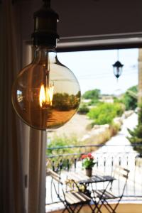une lampe de verre suspendue à une fenêtre avec vue sur un balcon dans l'établissement Joseluce, à Gudja